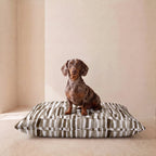 Perro salchicha sentado en cama para perro desenfundable antimanchas con estampado marrón y blanco